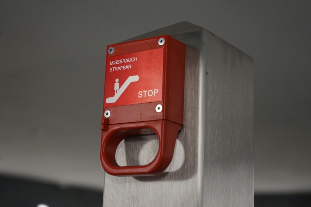 Emergency stop button representing AI governance and runtime containment for autonomous agents